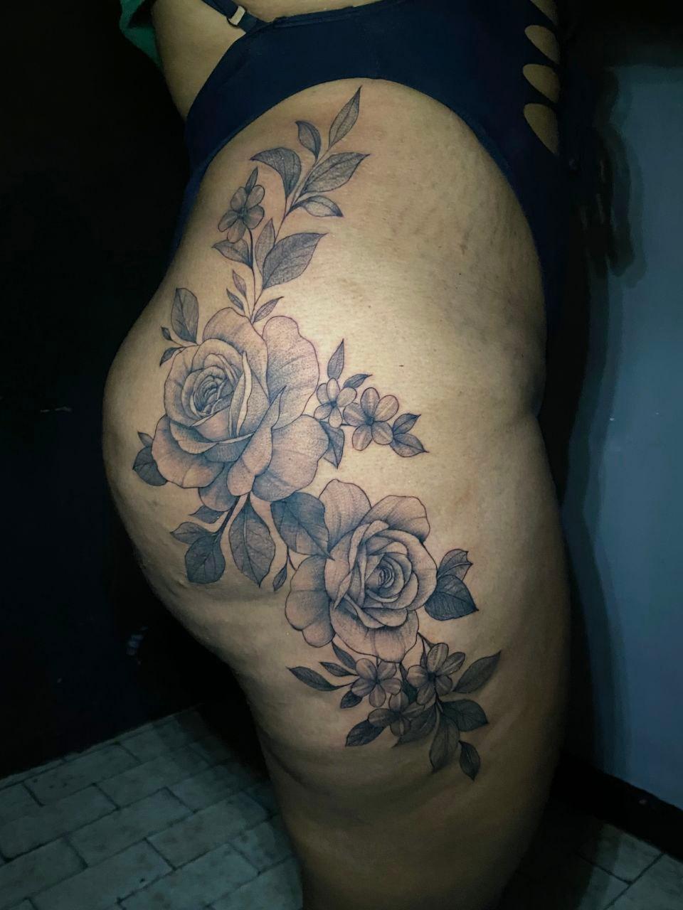 Tatuaje de rosas en muslo con composición orgánica